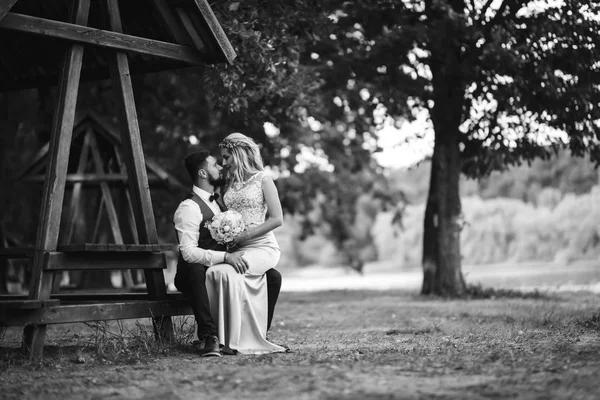 新郎新娘的性感黑白相间的胎儿 婚礼当天 一对时髦的新婚夫妇在公园里摆姿势 英俊的胡子新郎仰慕并亲吻漂亮的新娘 一起来 — 图库照片
