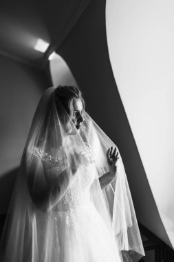 Düğün çiçekli güzel gelinin siyah-beyaz foto 'su, gelinlik giymiş çekici bir kadın. Mutlu yeni evli kadın. Düğün makyajlı ve saç stili gelin. Gelinin sabahı. 