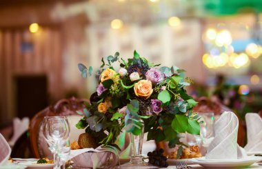 Düğün günü masada güzel çiçekler. Çiçeklerle süslenmiş düğün masası. Evlilik için güzel bir düğün restoranı. Kutlama için renkli bir süsleme. Salonda buket ve çiçekler.