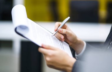 Bir adam zıtlık, yasal ya da iş anlaşmaları imzalar. Genç bir ofis çalışanının kalemini tutan erkek notlar alır. İş adamı ofis masasında oturuyor ve modern ofiste bir belge imzalıyor..