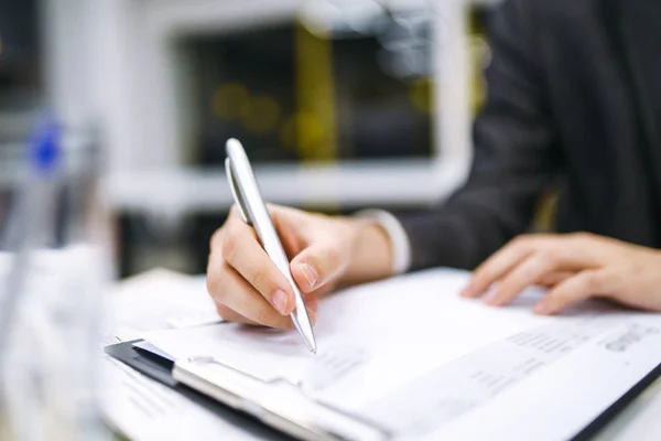 A man signs a contrac, legal or business agreements. Male hand with pen of young office worker makes notes. Business man  sitting at office desk and signing a document in modern office.