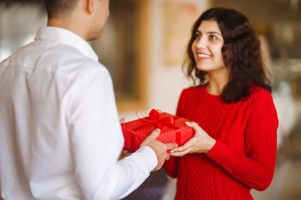 男人给他的女朋友一个圣诞礼物 圣诞前夕 手握礼物的一对快乐的夫妇在一起欢度着圣诞 寒假的概念 情侣们互赠礼物 情人节的概念 — 图库照片