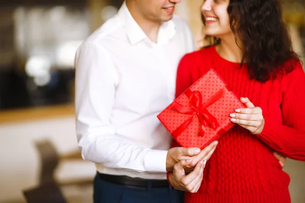 男人手里拿着圣诞礼物的女人 圣诞前夕 手握礼物的一对快乐的夫妇在一起欢度着圣诞 寒假的概念 情侣们互赠礼物 情人节的概念 — 图库照片