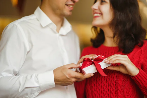 情人节 节日和惊喜的概念 男人送给女人一个红丝带礼品盒 一对恋人拥抱在一起 在餐厅里庆祝情人节 情侣互赠礼物 — 图库照片
