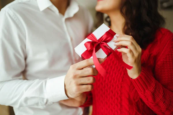 情人节 节日和惊喜的概念 男人送给女人一个红丝带礼品盒 一对恋人拥抱在一起 在餐厅里庆祝情人节 情侣互赠礼物 — 图库照片