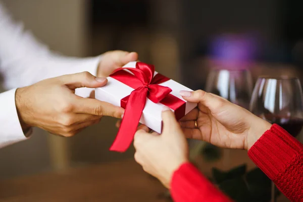 男人送给女人一个红丝带礼品盒 男人的手送给女孩惊喜礼品盒 年轻夫妇庆祝情人节 生日概念 — 图库照片
