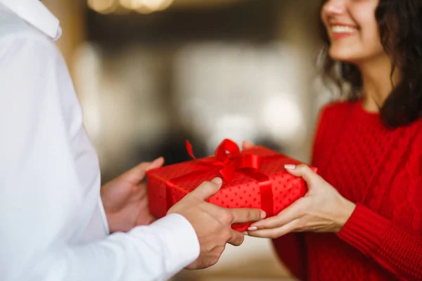 男人送给女人一个红丝带礼品盒 一对恋人拥抱在一起 在餐厅里庆祝情人节 情人节 节日和惊喜的概念 关系和爱情 — 图库照片