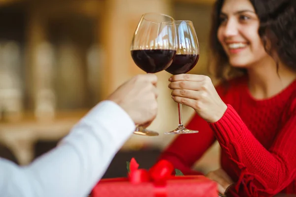 若いカップルはロマンチックなディナーを食べ 赤ワインのグラスで乾杯します 甘いカップルは彼らの記念日を祝う バレンタインデーのお祝いのコンセプト 驚きと愛の概念 — ストック写真