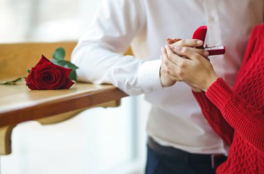 Yakışıklı bir adam restoranda güzel bir kadına evlenme teklif ediyor. Çekici bir kadının evlenme teklifi almasına şaşırdım. Sevgililer Günü kutlaması konsepti. İlişki ve aşk kavramı.