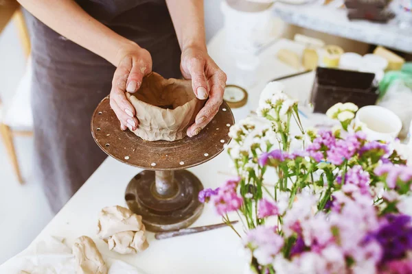 Hands sculpts a cup from clay pot. Woman working on the potter\'s wheel. Workshop on modeling on the potter\'s wheel. Handmade consept.