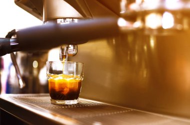 Kahve makinesinde sade kahve sabahı. Kahve makinesi taze kahve hazırlıyor ve restoranda, barda ya da barda fincanlara dökülüyor. Profesyonel mayalama. Hazırlık hizmeti kavramı.