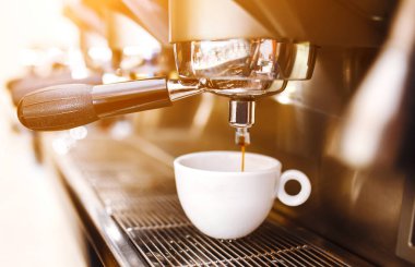 Kahve makinesinde sade kahve sabahı. Kahve makinesi taze kahve hazırlıyor ve restoranda, barda ya da barda fincanlara dökülüyor. Profesyonel mayalama. Hazırlık hizmeti kavramı.