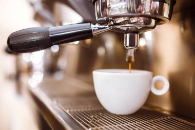 Kahve makinesinde sade kahve sabahı. Kahve makinesi taze kahve hazırlıyor ve restoranda, barda ya da barda fincanlara dökülüyor. Profesyonel mayalama. Hazırlık hizmeti kavramı.