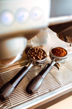 Kahve filtresi ve kavrulmuş kahve çekirdeği. Kahve makinesi taze kahve hazırlıyor ve restoranda, barda ya da barda fincanlara dökülüyor. Hazırlık hizmeti kavramı.