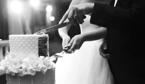 两只手切结婚蛋糕的黑白照片 快乐的新娘和新郎在婚宴上正在切他们漂亮的结婚蛋糕 结婚和庆祝的概念 — 图库照片