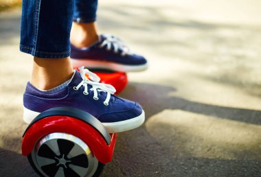 Kadın bacakları jimnastik tahtasında. Beyaz uçan kaykaylı biri. Elektrikli hiroskoper sürücüsü. Kendi kendini dengeleyen iki tekerlekli sörf tahtası ya da kaykay scooterı.