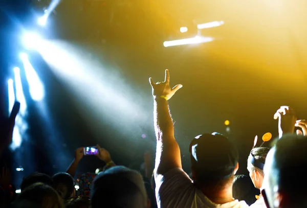 ステージの上から音楽祭で手を挙げ 光が流れ落ちる観客 観客は手を挙げて踊り コンサートを楽しんでいます — ストック写真