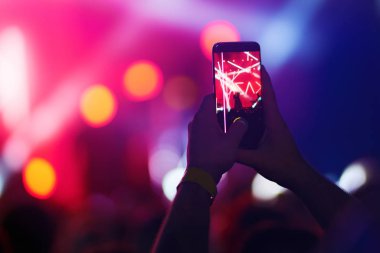 Telefon kayıtlarıyla birlikte canlı müzik festivali. Halk müziği konseri sırasında insanlar akıllı telefonlarıyla fotoğraf çekiyorlar. Kalabalık ellerini kaldırıyor, dans ediyor ve konserin tadını çıkarıyor..