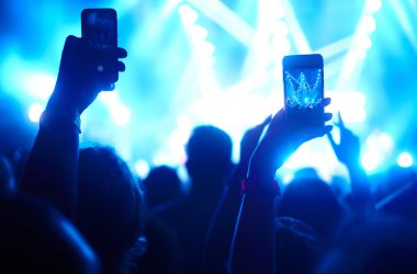 Telefon kayıtlarıyla birlikte canlı müzik festivali. Halk müziği konseri sırasında insanlar akıllı telefonlarıyla fotoğraf çekiyorlar. Kalabalık ellerini kaldırıyor, dans ediyor ve konserin tadını çıkarıyor..