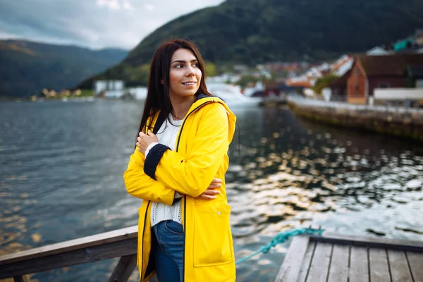 这个穿着黄色夹克的女游客在挪威的湖上摆姿势 在挪威高山的背景下 活跃的女人在湖边放松 生活方式 野外生活 — 图库照片