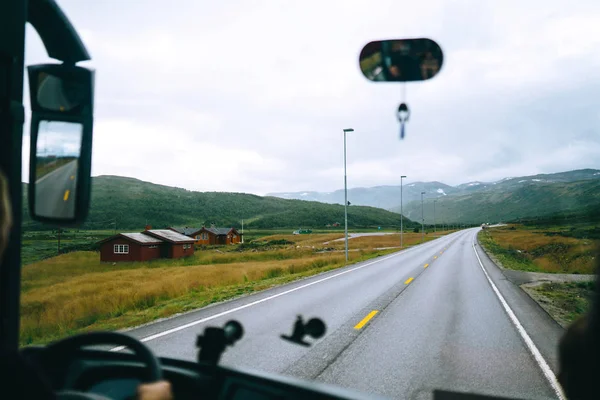 Norway road landscape on high mountains. Photo of the road among the mountains from the bus window. Travelling, lifestyle, adventure, wild nature concept.