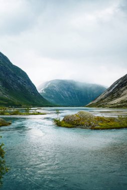 Norveç 'in resimli manzara dağları. Göl manzarası çok güzel. Sabah Dağ Gölü 'nün kayalık kıyısı. Seyahat, yaşam tarzı, vahşi doğa konsepti..
