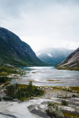 Norveç 'in resimli manzara dağları. Göl manzarası çok güzel. Sabah Dağ Gölü 'nün kayalık kıyısı. Seyahat, yaşam tarzı, vahşi doğa konsepti..