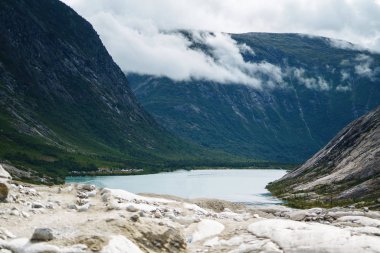 Norveç 'in resimli manzara dağları. Göl manzarası çok güzel. Sabah Dağ Gölü 'nün kayalık kıyısı. Seyahat, yaşam tarzı, vahşi doğa konsepti..