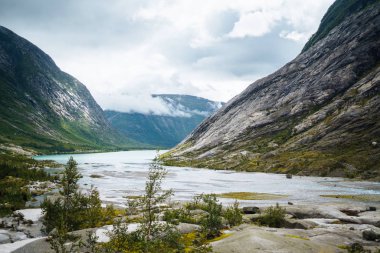 Norveç 'in resimli manzara dağları. Göl manzarası çok güzel. Sabah Dağ Gölü 'nün kayalık kıyısı. Seyahat, yaşam tarzı, vahşi doğa konsepti..