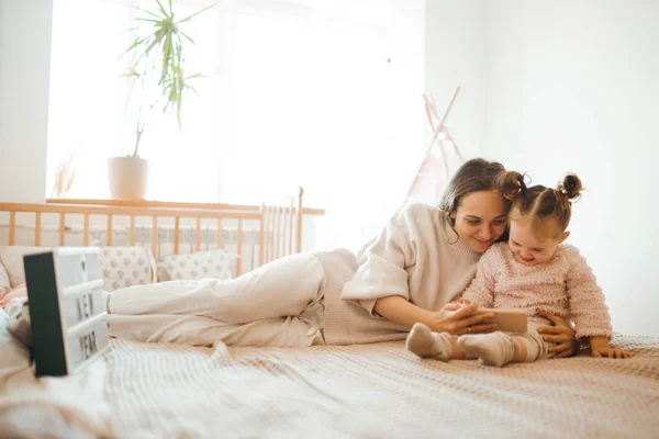 Cheerful Mother Her Daughter Little Daughter Watching Cartoons Phone Lying — Stock Photo, Image
