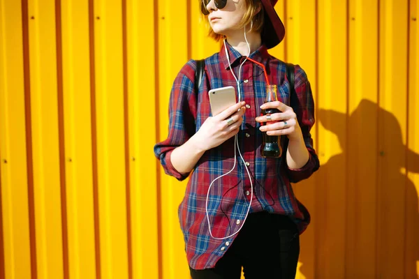 Młoda Nastolatka Drinkiem Telefonem Ręku Pozująca Nad Pustym Żółtym Tłem — Zdjęcie stockowe