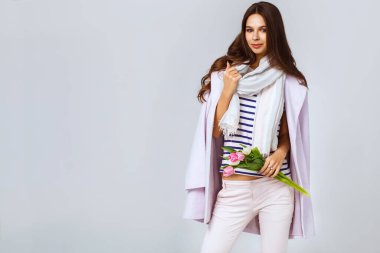 8 Mart 'ta elinde laleler olan güzel bir genç kadının moda fotoğrafı. Bahar konsepti. 