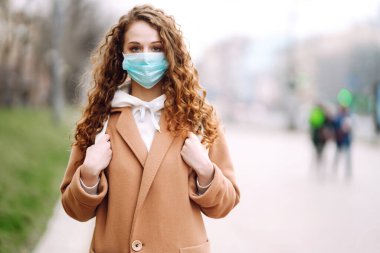 Sokakta yüzü koruyucu steril tıbbi maske takmış bir kız. Kadın, yüz maskesi tak, karantina şehrinde virüs, salgın ve salgın hastalıklardan koru. Corona virüsü.