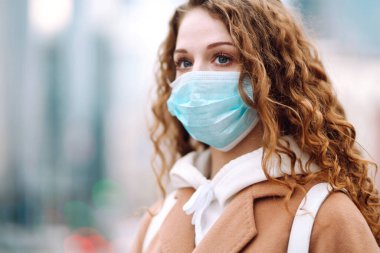 Sokakta yüzü koruyucu steril tıbbi maske takmış bir kız. Kadın, yüz maskesi tak, karantina şehrinde virüs, salgın ve salgın hastalıklardan koru. Corona virüsü.