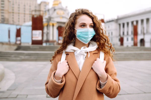 Sokakta yüzü koruyucu steril tıbbi maske takmış bir kız. Kadın, yüz maskesi tak, karantina şehrinde virüs, salgın ve salgın hastalıklardan koru. Corona virüsü.