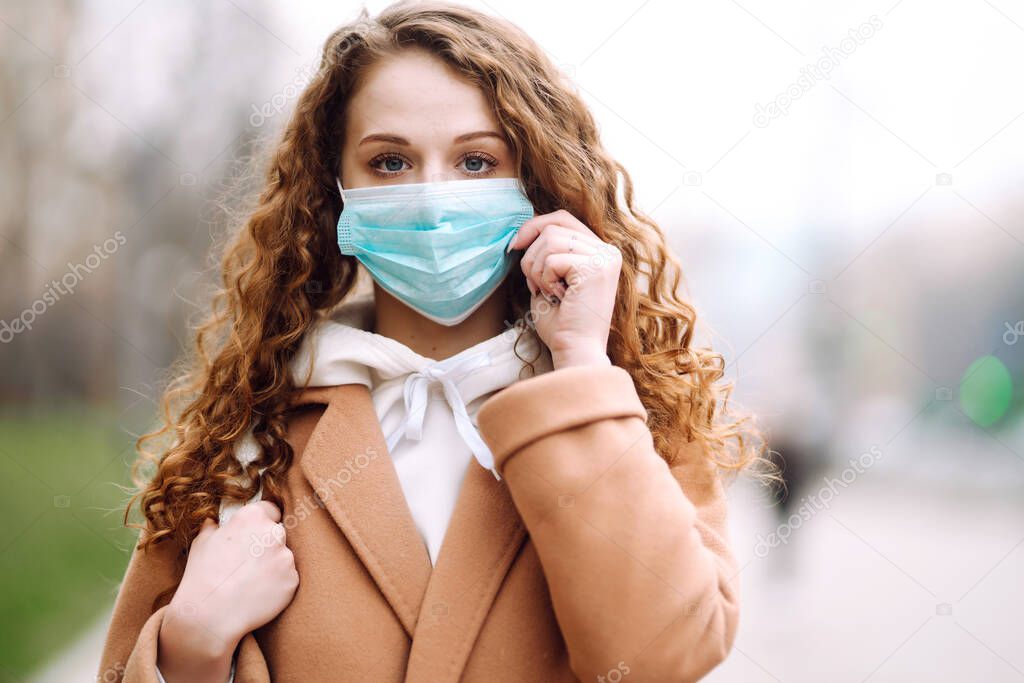 Girl in protective sterile medical mask on her face on the street. Woman, wear face mask, protect from infection of virus, pandemic, outbreak and epidemic of disease in  quarantine city. Corona virus.