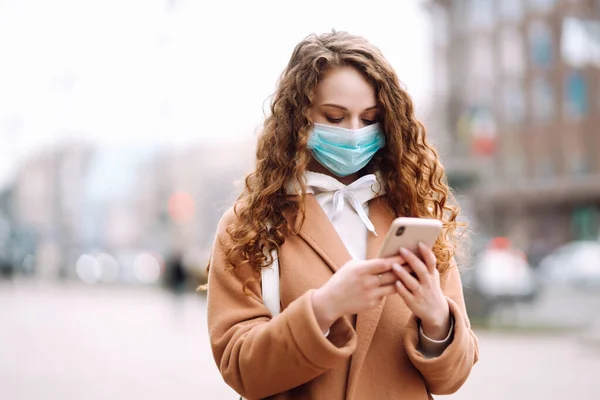 Gadis Dengan Masker Medis Steril Pelindung Wajahnya Dengan Telepon Kota — Stok Foto