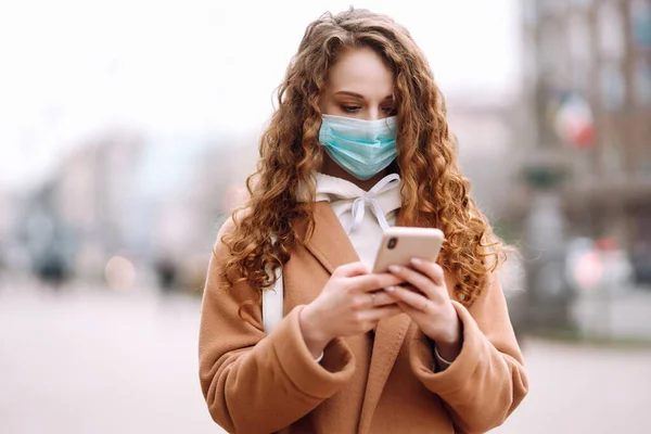 Gadis Dengan Masker Medis Steril Pelindung Wajahnya Dengan Telepon Kota — Stok Foto