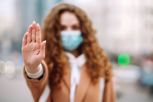 手を止めろサイン 彼女の顔に滅菌医療マスクの女性は ストップコロナウイルス発生のためのストップハンドジェスチャーを示しています 流行の広がりを防ぐという概念 — ストック写真