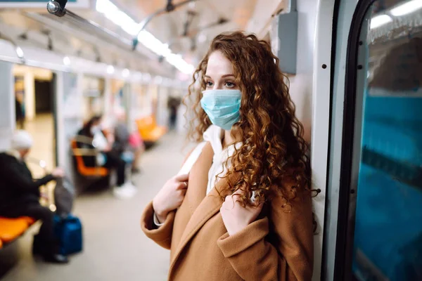 Metro vagonunda steril tıbbi maskeli bir kız. Kadın, yüz maskesi tak, karantina şehrinde virüs, salgın ve salgın hastalıklardan koru.. 