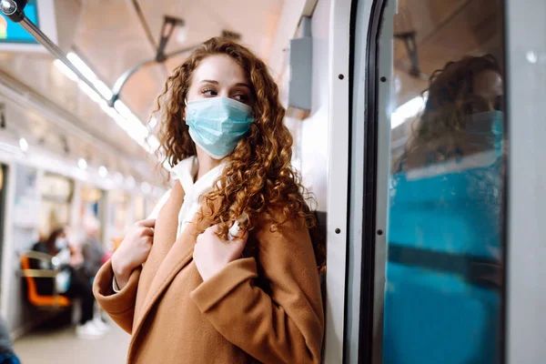 Metro vagonunda steril tıbbi maskeli bir kız. Kadın, yüz maskesi tak, karantina şehrinde virüs, salgın ve salgın hastalıklardan koru.. 