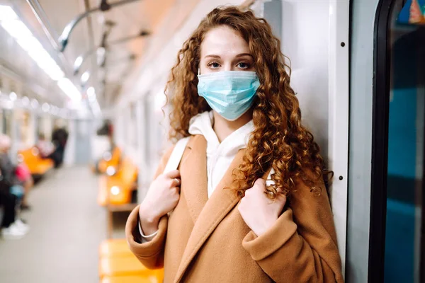Metro vagonunda steril tıbbi maskeli bir kız. Kadın, yüz maskesi tak, karantina şehrinde virüs, salgın ve salgın hastalıklardan koru.. 