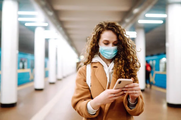Metro Istasyonunda Telefonu Olan Steril Tıbbi Maskeli Bir Kız Kadın — Stok fotoğraf