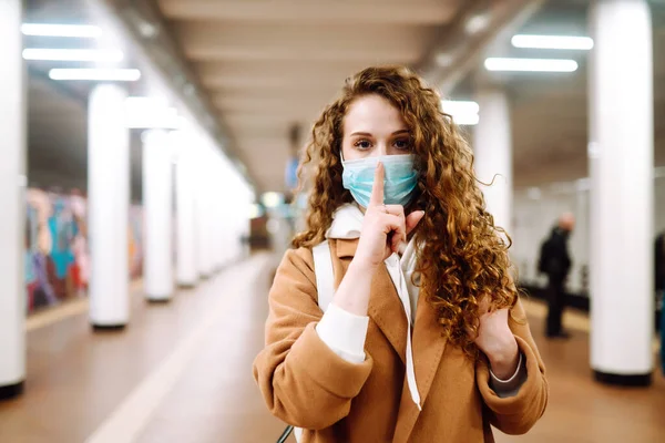 彼女の顔に保護滅菌医療マスクの女の子はジェスチャーを示しています シーッ 地下鉄駅で静粛に 感染症の拡大を防止し コロナウイルスを治療するという概念 隔離されたパンデミック — ストック写真