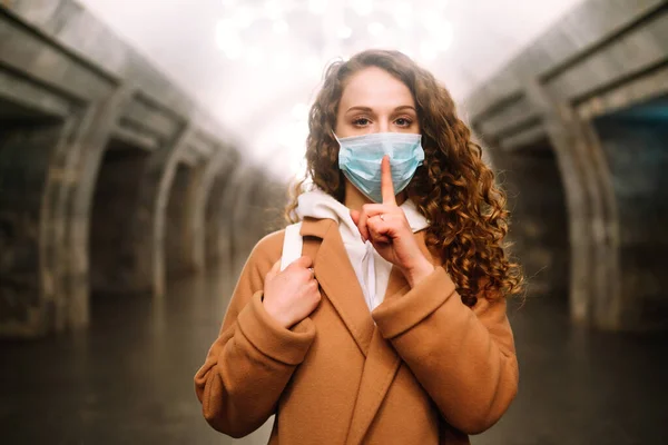 空の地下鉄駅で彼女の顔に保護滅菌医療マスクの少女 顔マスクを着用し ウイルスの感染 パンデミック 感染症や検疫都市での病気の流行から保護します — ストック写真