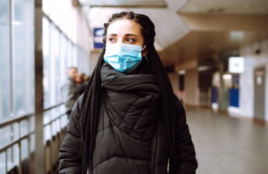 Karantina şehrinde yüzü steril tıbbi maske takmış bir kız. Kadın, yüz maskesi tak, karantina bölgesinde virüs, salgın ve salgın hastalıklardan koru. Covid 19.