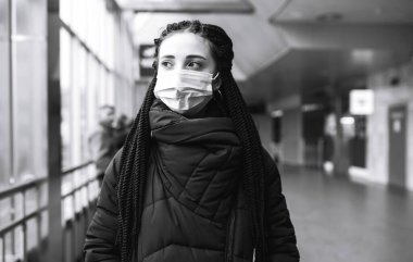 Kızın koruyucu steril tıbbi maske karantina bölgesinde siyah beyaz fotoğrafı. Kadın, yüz maskesi tak, karantina şehrinde virüs, salgın ve salgın hastalıklardan koru.