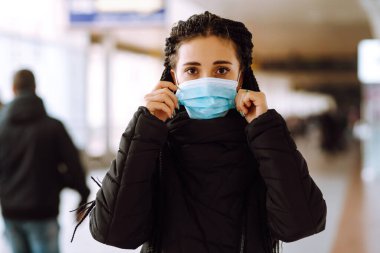 Karantina şehrinde yüzü steril tıbbi maske takmış bir kız. Kadın, yüz maskesi tak, karantina bölgesinde virüs, salgın ve salgın hastalıklardan koru. Covid 19.