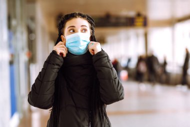 Karantina şehrinde yüzü steril tıbbi maske takmış bir kız. Kadın, yüz maskesi tak, karantina bölgesinde virüs, salgın ve salgın hastalıklardan koru. Covid 19.