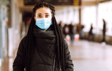 Karantina şehrinde yüzü steril tıbbi maske takmış bir kız. Kadın, yüz maskesi tak, karantina bölgesinde virüs, salgın ve salgın hastalıklardan koru. Covid 19.
